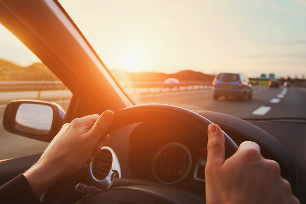 hands of car driver on steering wheel