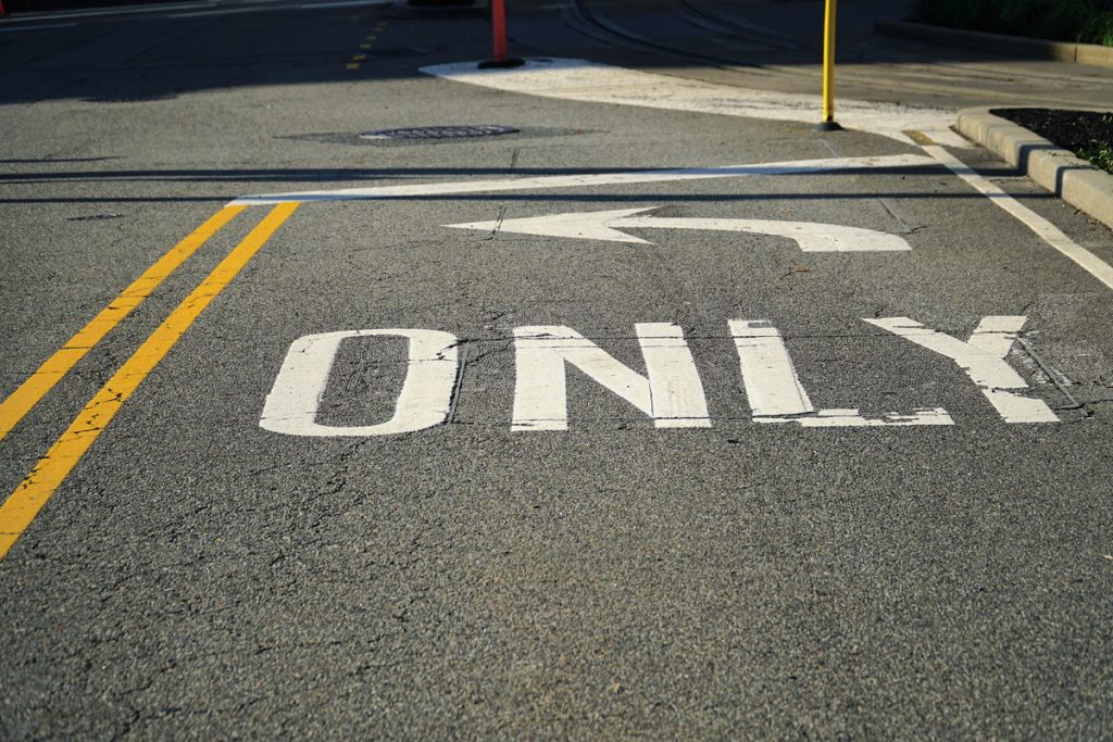 Asphalt lane in big modern city with only left symbol