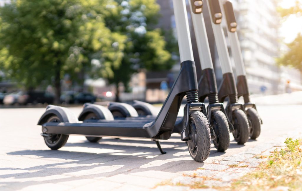 Electric kick scooters in city. E vehicle for rent. Urban modern transportation and technology concept.